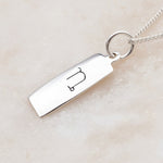 Capricorn zodiac necklace in sterling silver on a white surface 