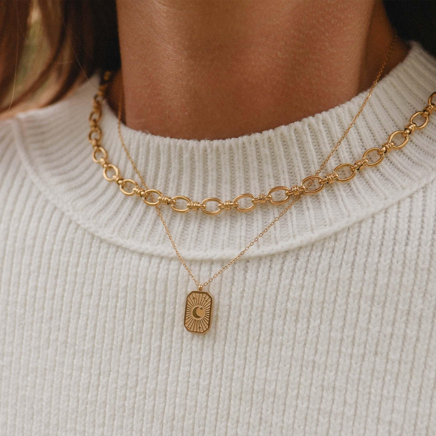 Woman wearing a white jumper and gold Necklaces - womens gold jewellery australia
