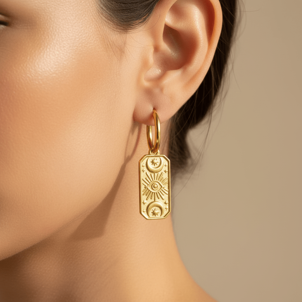 waterproof stainless steel celestial charm gold huggie hoop earrings being worn