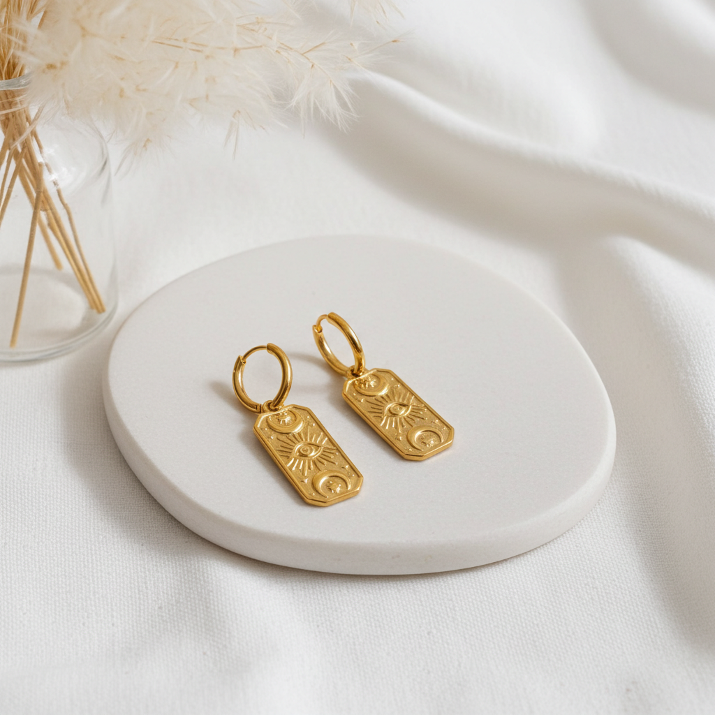 Celestial Gold hoop earrings on a white ceramic plate with a soft white background