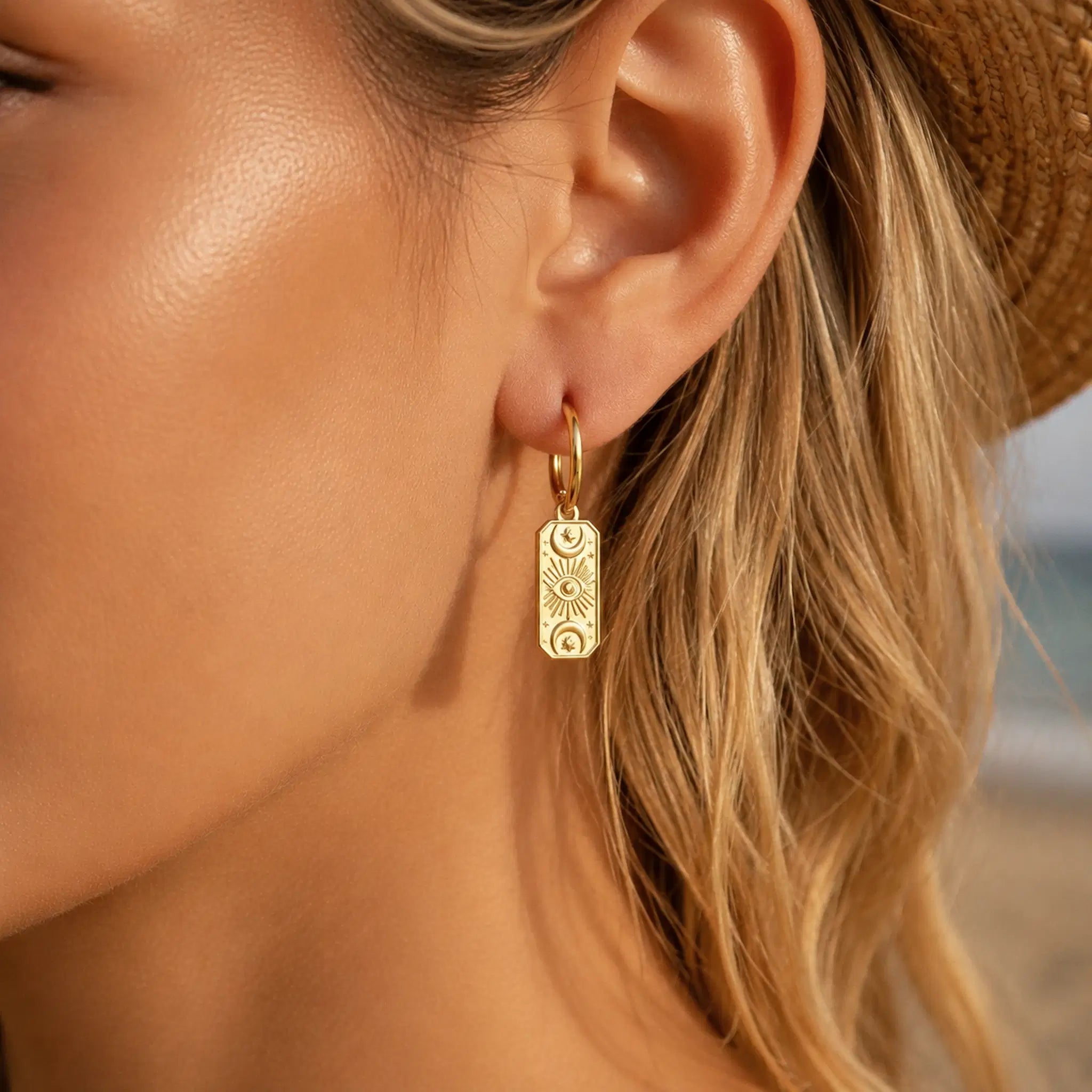 close up of a woman with blonde hair wearing gold celestial hoop earrings