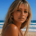 blonde woman on the beach wearing stainless steel chunky gold waterproof hoop earrings