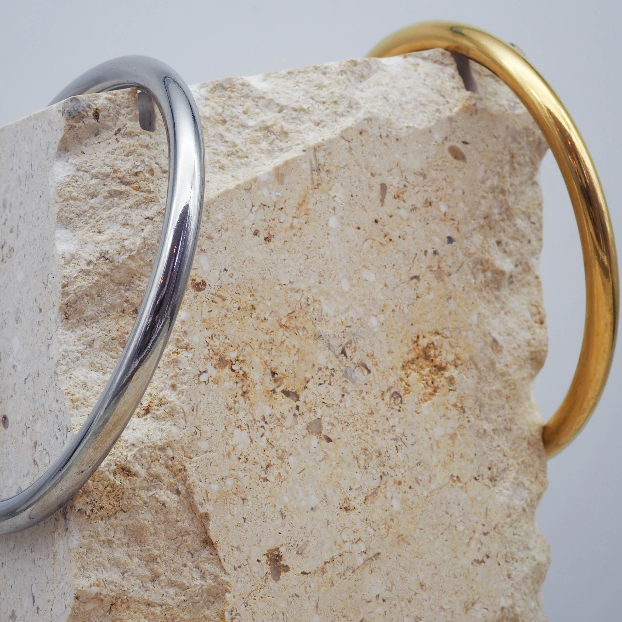 Close-up of silver and gold thin bangle bracelets made with stainless steel - waterproof jewellery