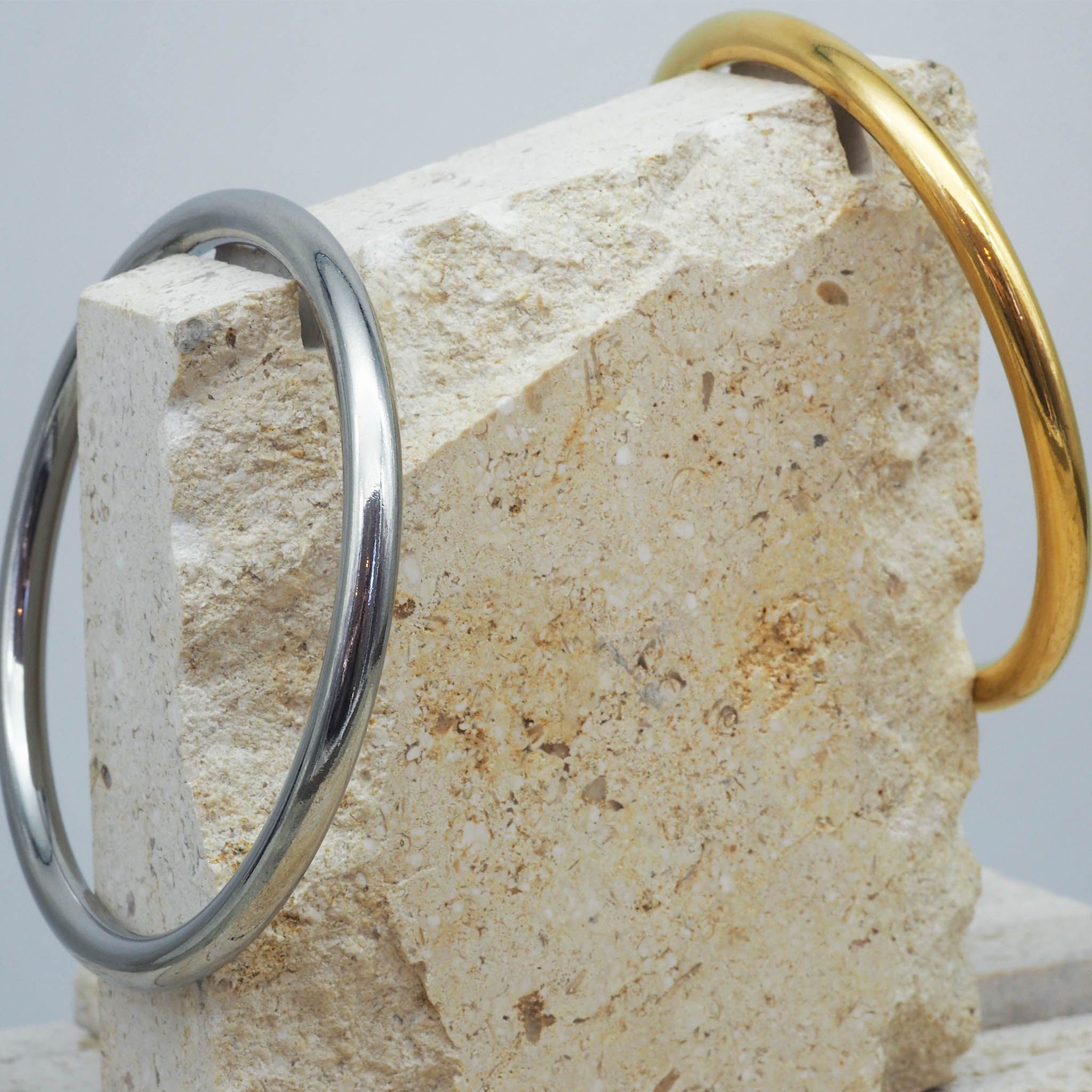 Silver and gold bangle bracelets on white stone - waterproof jewellery by indie and harper