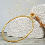 Thin gold bangle with a brushed gold finish - waterproof jewellery by indie and harper