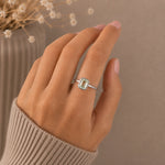 womans hand wearing a Sterling Silver ring with a emerald-cut, bezel set green amethyst gemstone on a beige background