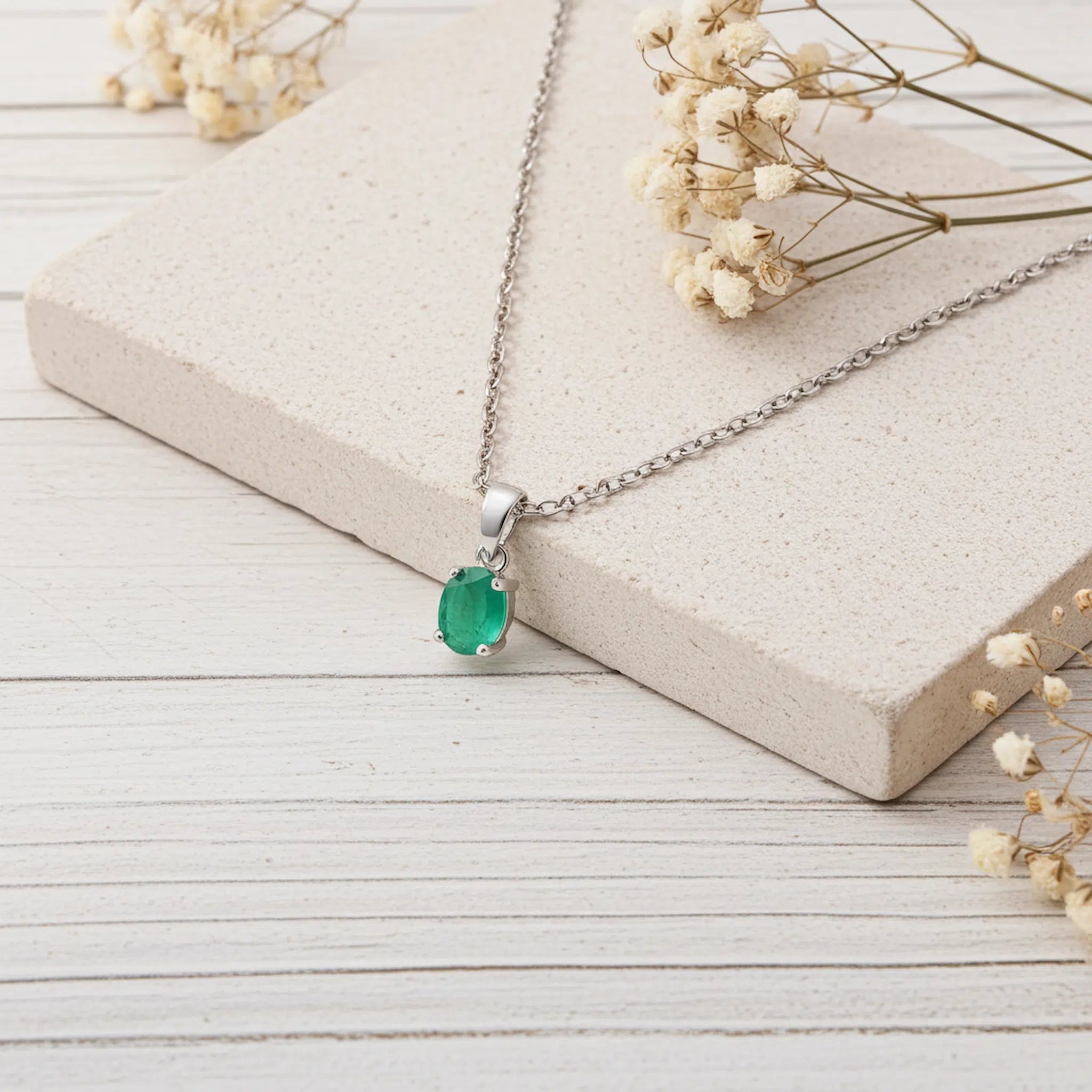 sterling silver fine chain necklace with a faceted natural claw set oval emerald gemstone pendant