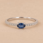 Sterling Silver pave stacking ring with a oval faceted  claw set centre sapphire gemstone on a beige background