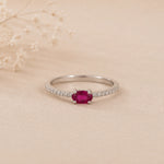 sterling Silver cubic zirconia pave style stacking ring with a red ruby gemstone on a beige background