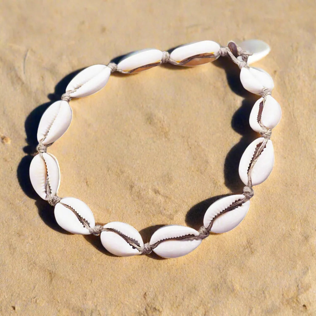 Bracelet made of white shell beads on a beige stone background