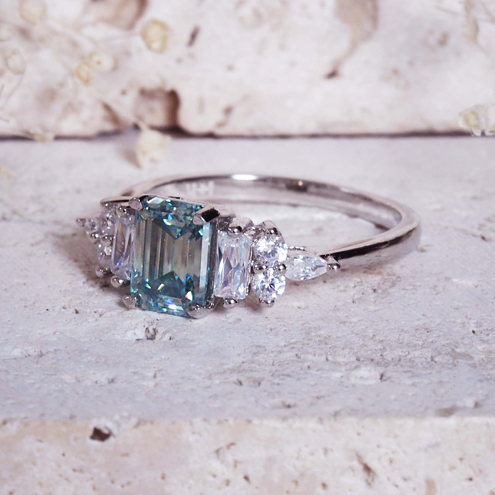 Silver ring with a blue gemstone on a textured surface