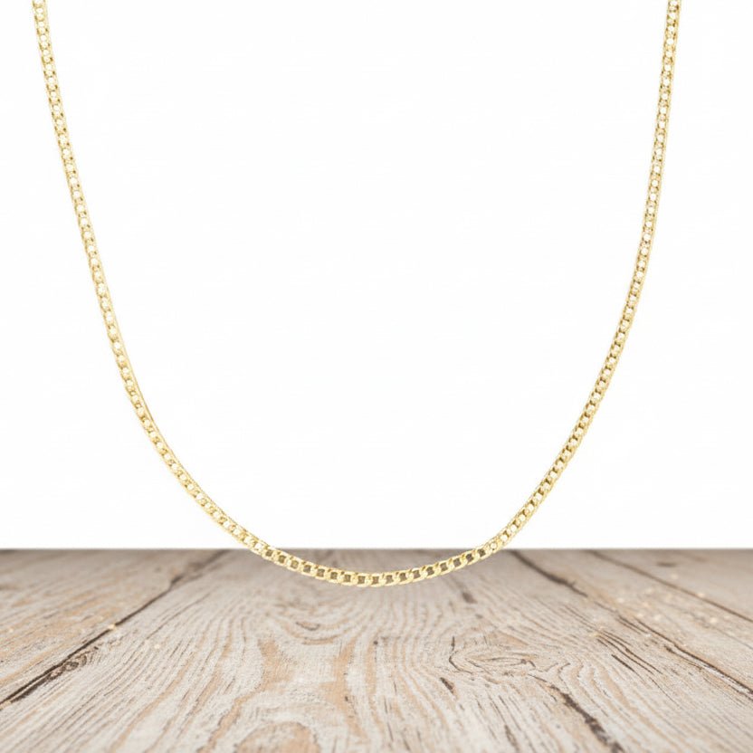 Gold chain necklace on a wooden surface