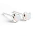 Pair of silver stud earrings with opal stones on a white background