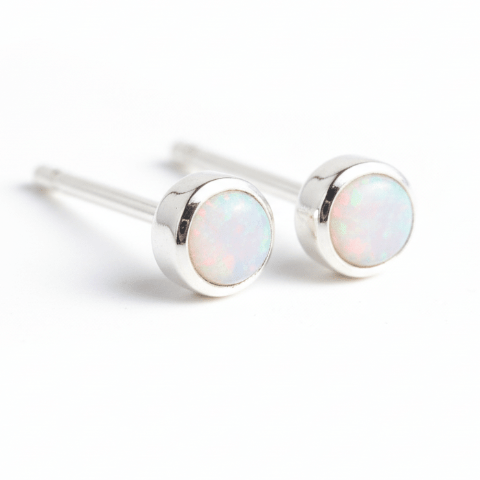 Pair of silver stud earrings with opal stones on a white background