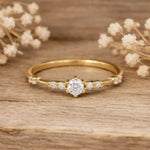 Gold ring with czs on a wooden surface with dried flowers
