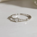 dainty sterling Silver ring with small cubic zirconias on a light surface