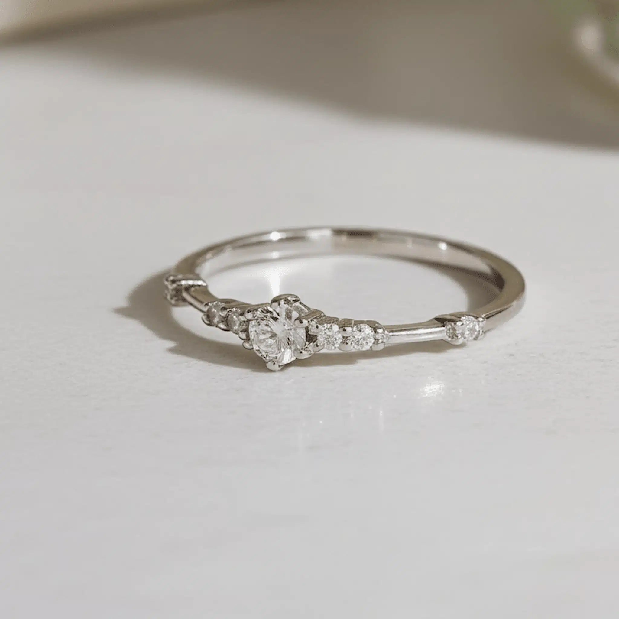 dainty sterling Silver ring with small cubic zirconias on a light surface