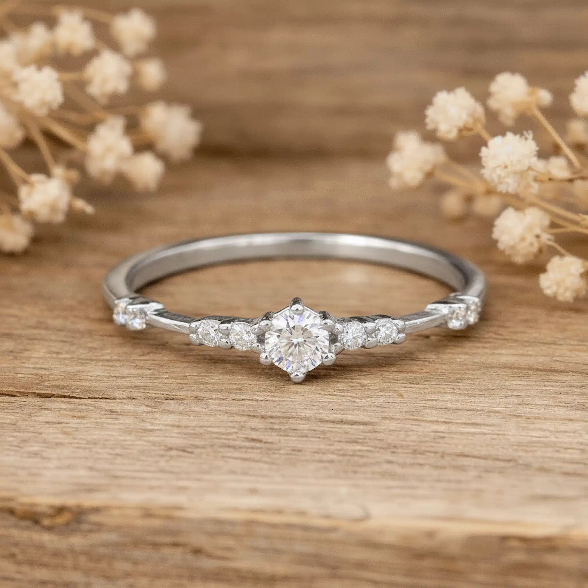 Silver cz ring on a wooden surface with dried flowers