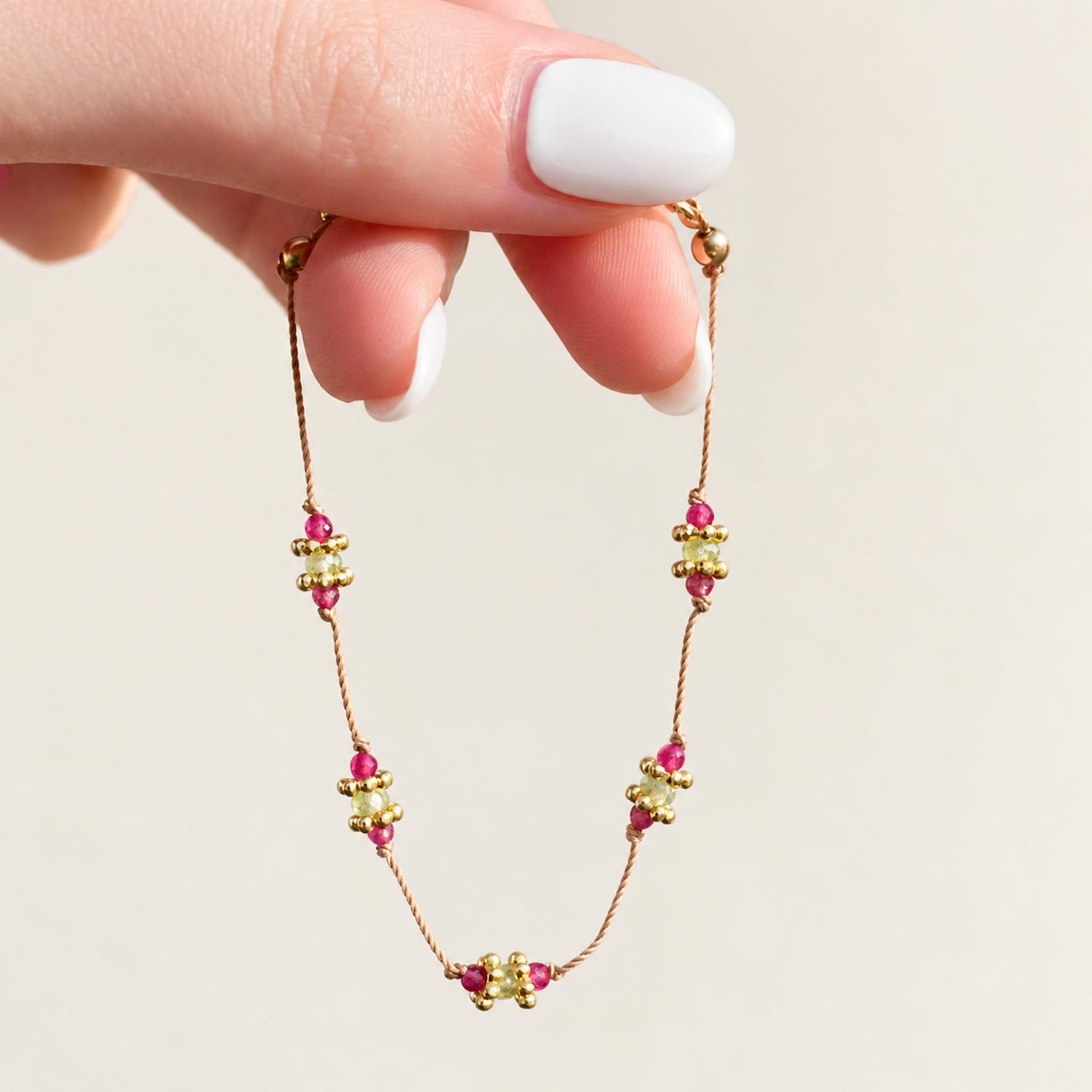 gold dainty goddess rubellite peridot beaded bracelet being held