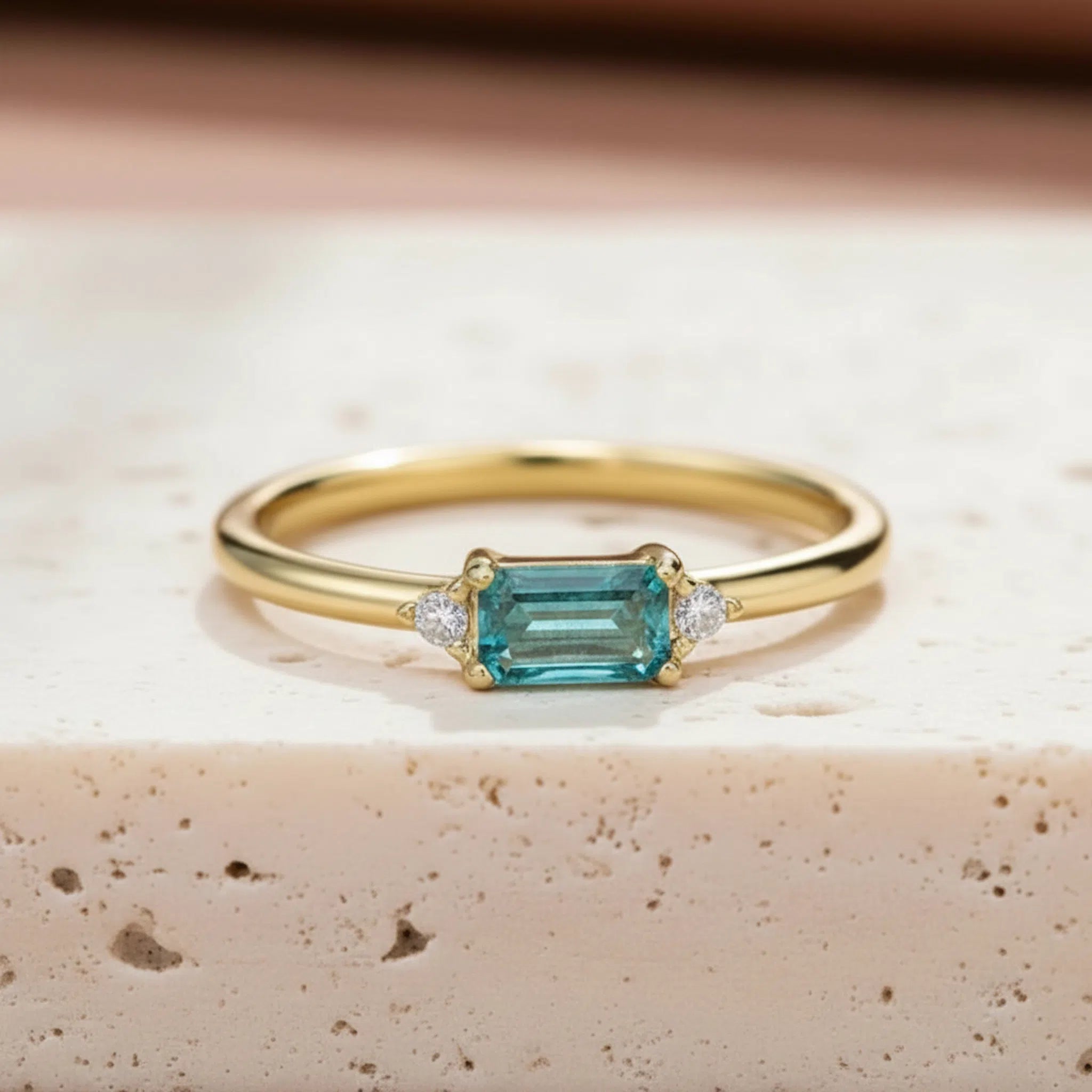 Dainty gold plated sterling silver gemstone ring with rectangular blue green tourmaline centre stone, round cubic zirconia side accents, and slim polished stackable band