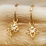 dainty gold hoop earrings with lotus flower charm pendants 
