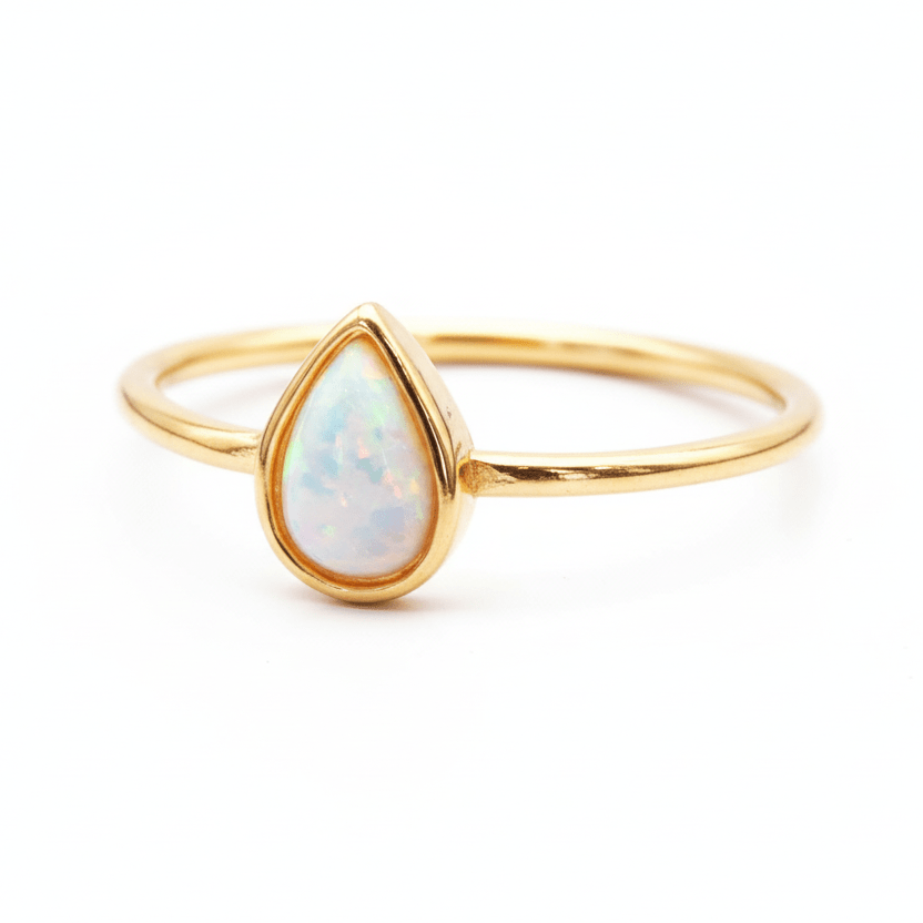 Gold ring with a teardrop-shaped opal stone on a white background