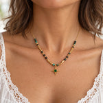 Dainty gold turquoise beaded necklace with green starlight pendant worn with a white lace top