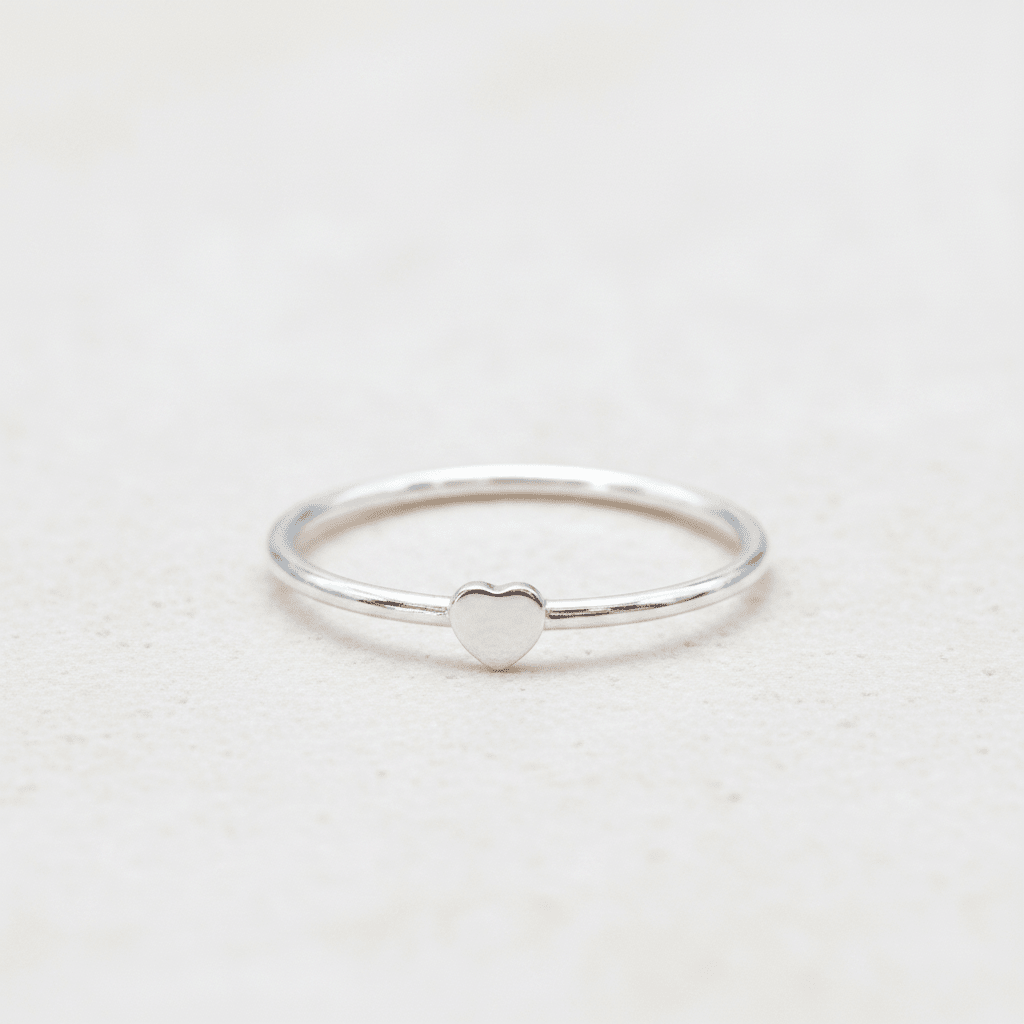 Silver ring with a heart-shaped design on a light gray background
