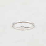 Silver ring with a heart-shaped design on a light gray background