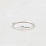 Silver ring with a heart-shaped design on a light background