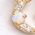 Gold pendant with opal and clear cubic zirconias gemstones on a light background