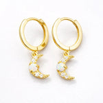 Gold hoop earrings with moon-shaped charms with opal and cubic zirconias on a white background