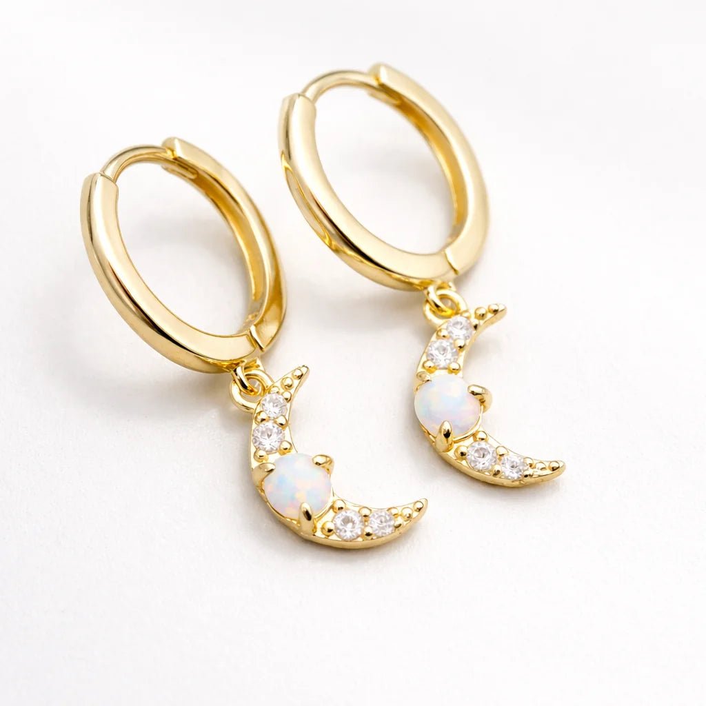 Gold hoop earrings with moon-shaped charms on a white background