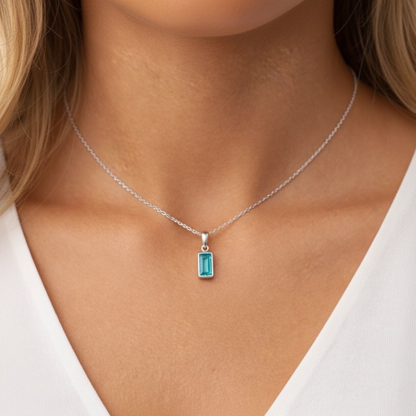 Necklace with a blue gemstone pendant worn by a person
