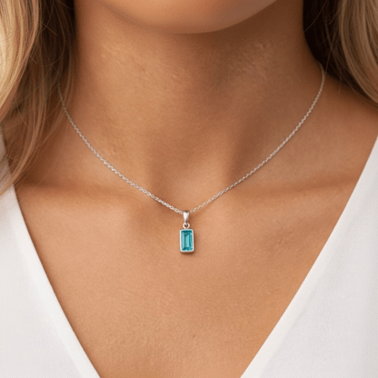 Necklace with a blue gemstone pendant worn by a person