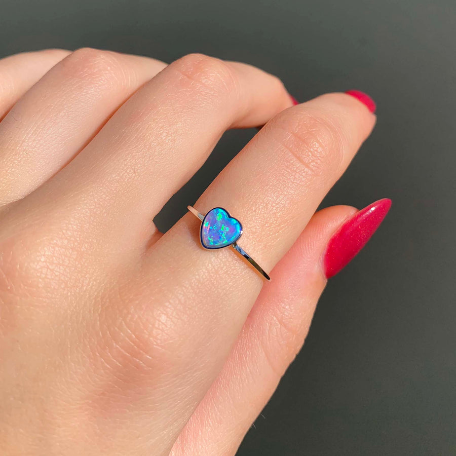 dainty opal heart ring - sterling silver ring with synthetic blue opal shining bright in the natural sunlight - beautiful opal jewellery by online jewellery brand indie and harper