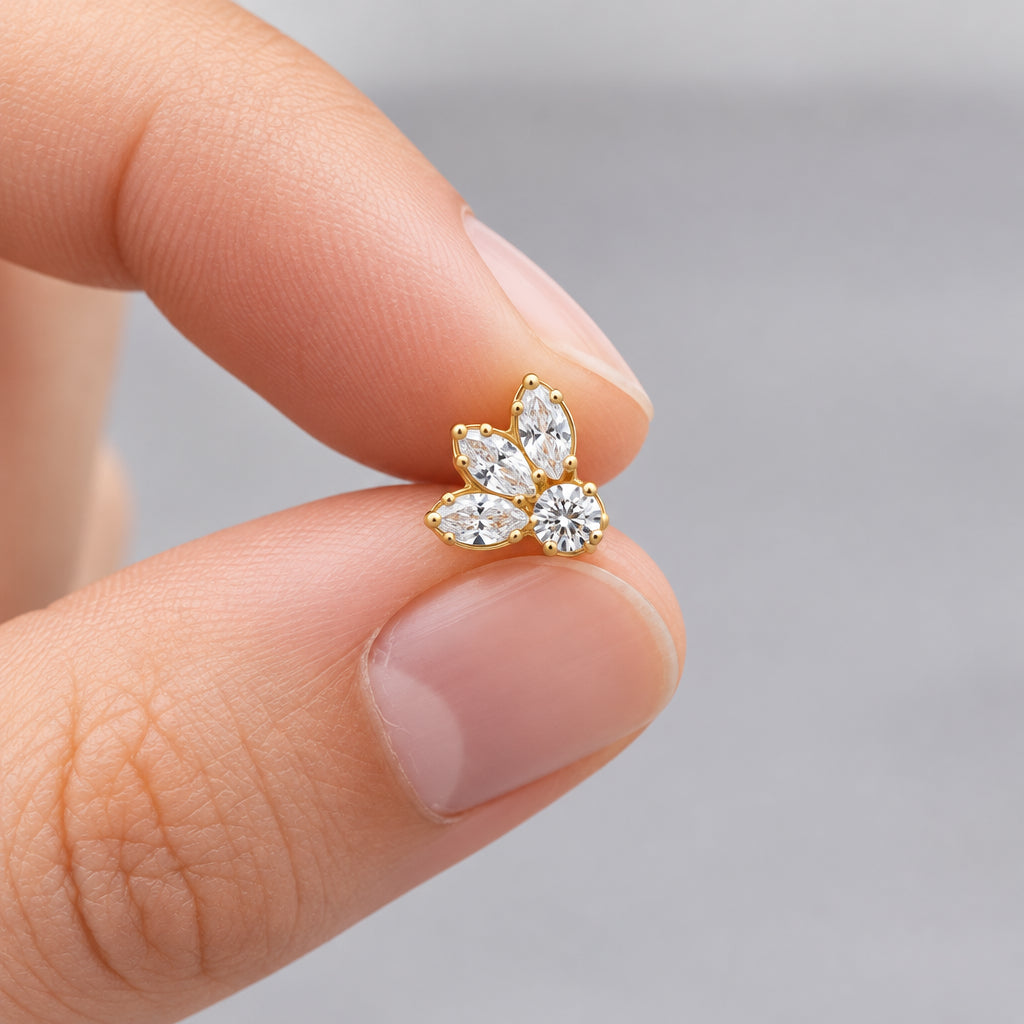 Tiny gold petal flat back earring held between two fingers