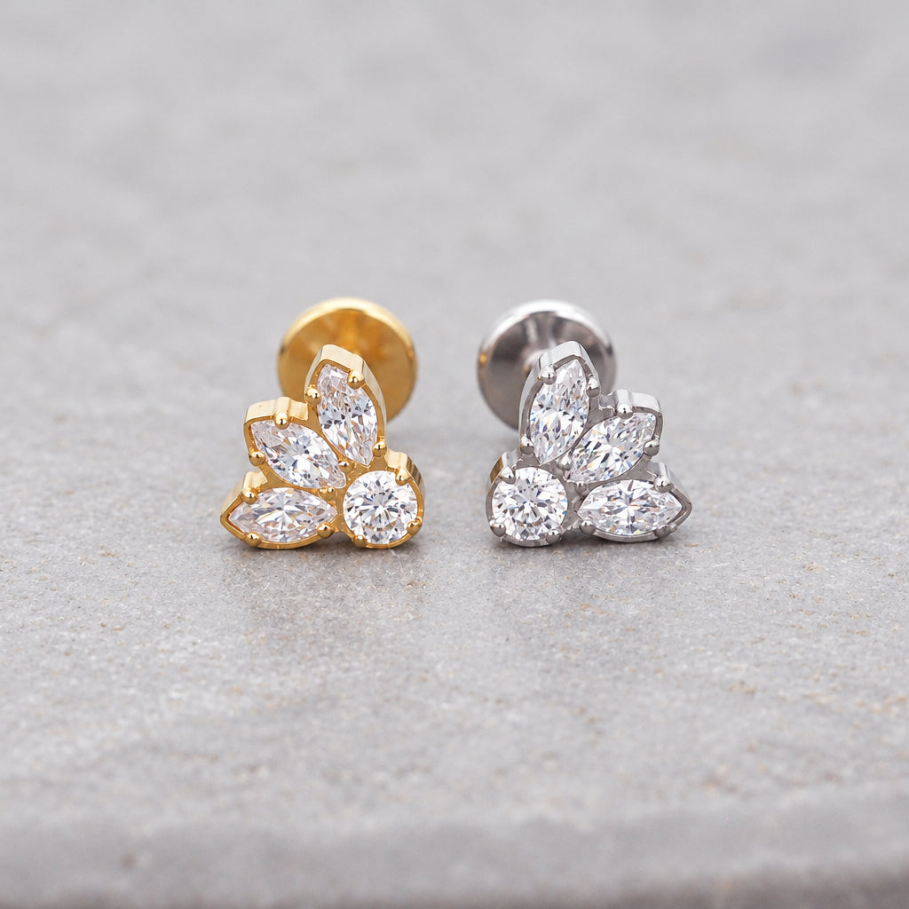 Gold and silver petal flat back earrings with cubic zirconia on a grey surface