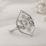 Silver ring with floral design on a light background