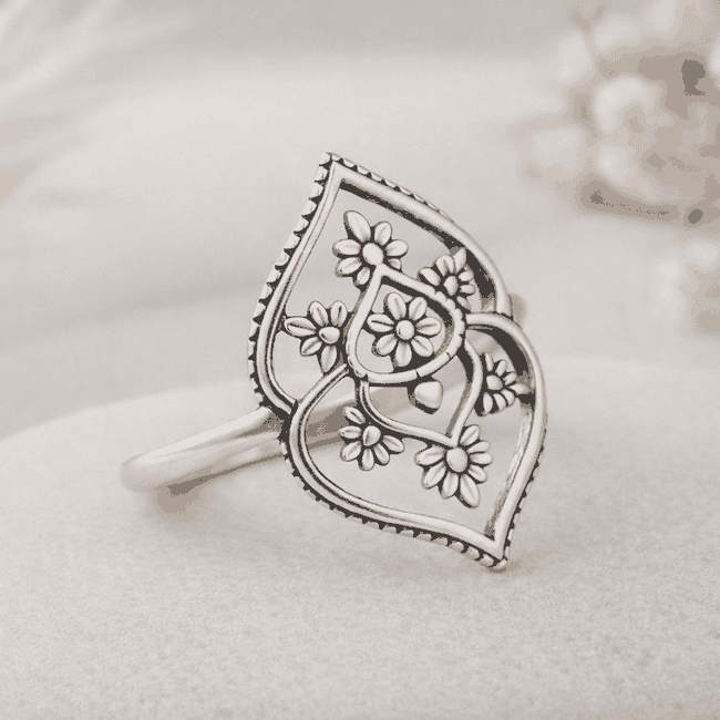 Silver ring with floral design on a light background