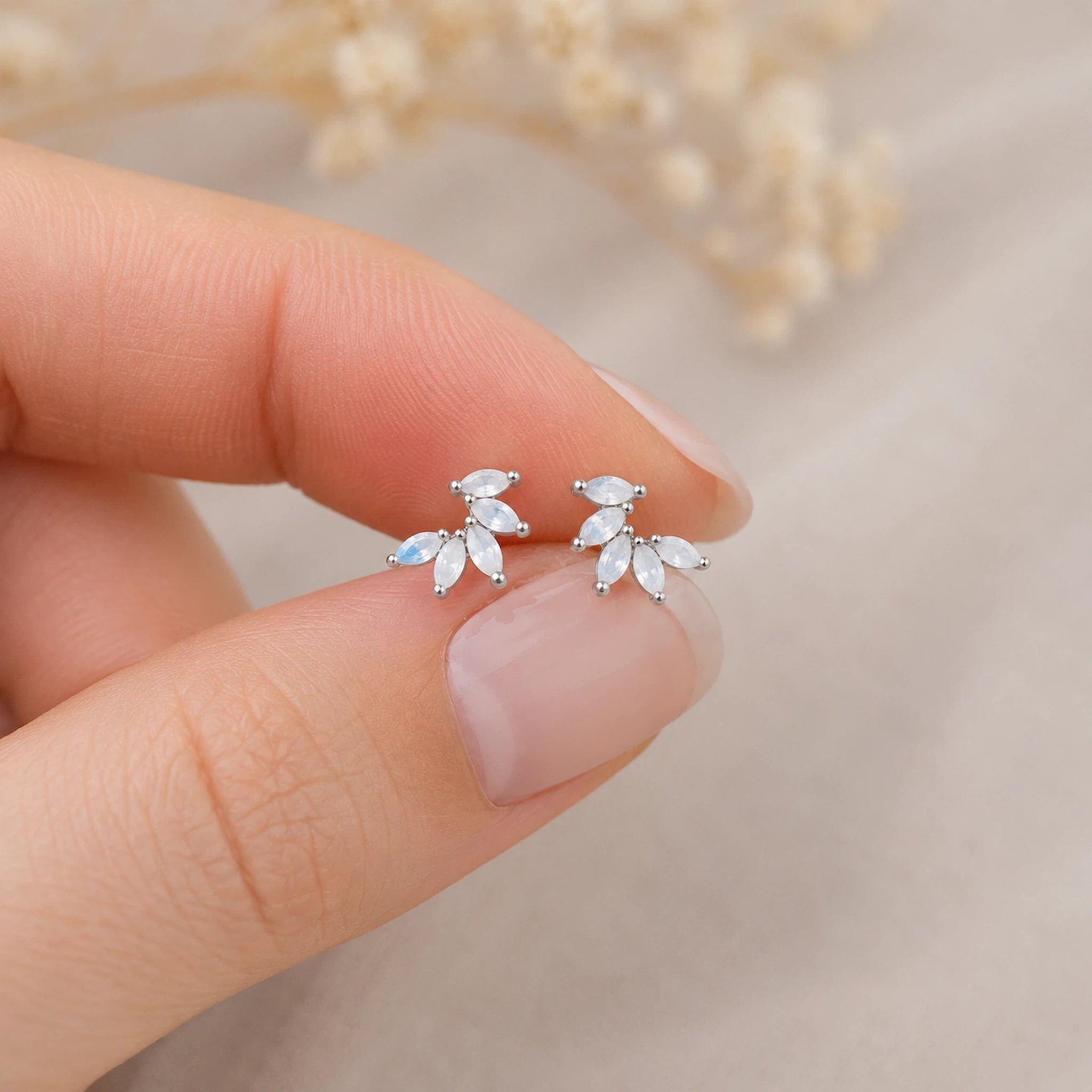 fingers holding sterling silver stud earrings with marquise shaped czs