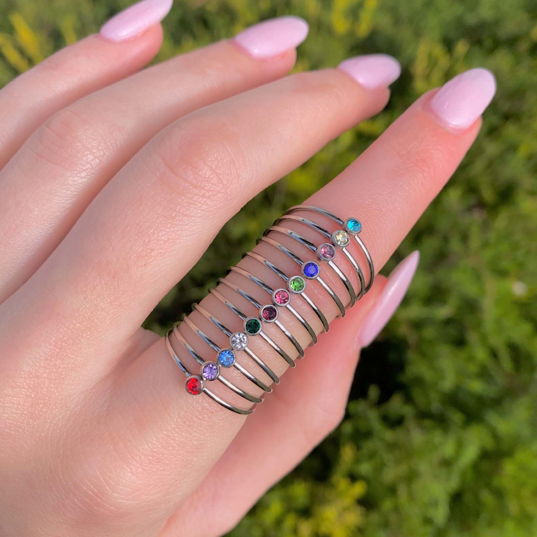Dainty silver stacker ring featuring multiple colorful cubic zirconia stones arranged along a sleek band.