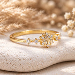 Gold snowflake ring with clear stones, angled view