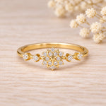 Gold snowflake stacking ring with 12 clear cubic zirconia on a slim polished band, front view