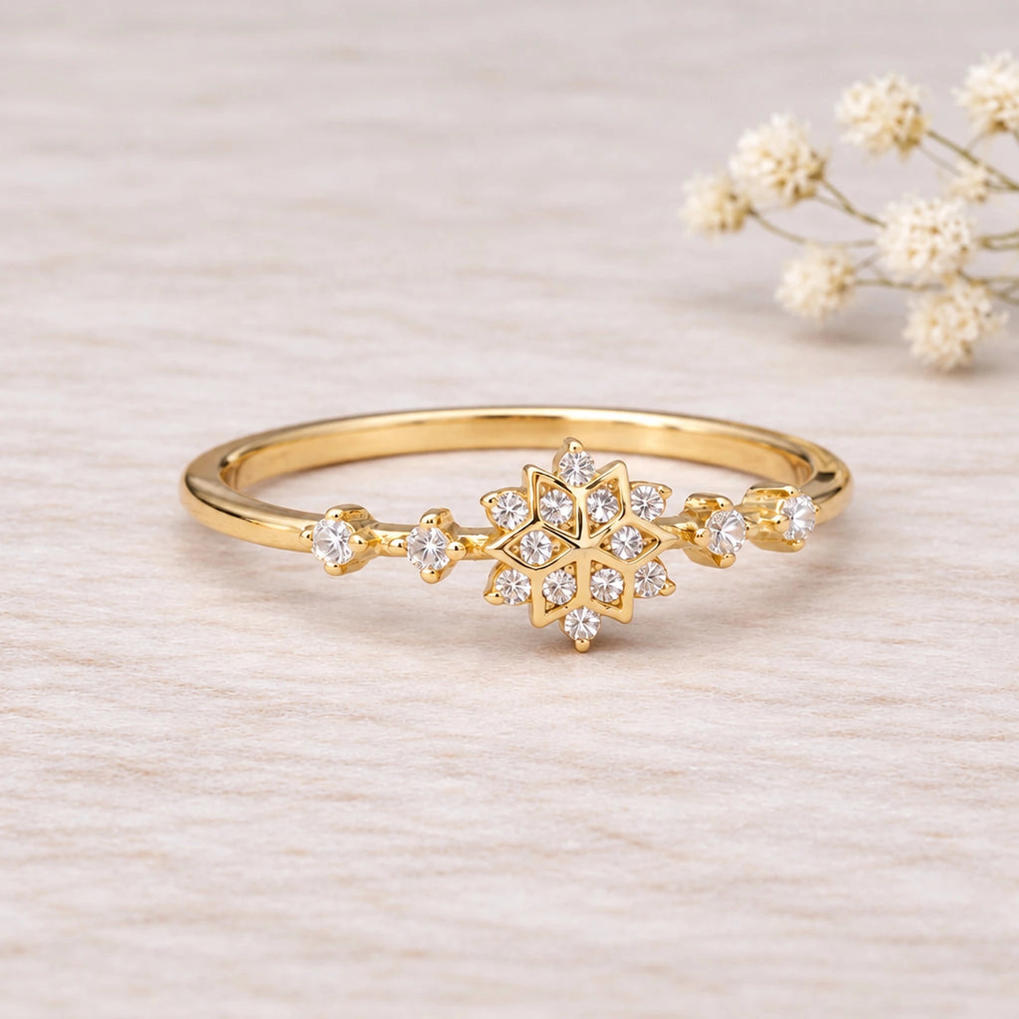 Gold snowflake ring with a clear cubic zirconia starburst cluster, close-up