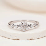 Sterling Silver ring with a delicate snowflake clear coloured cubic zirconia design on a white stone surface