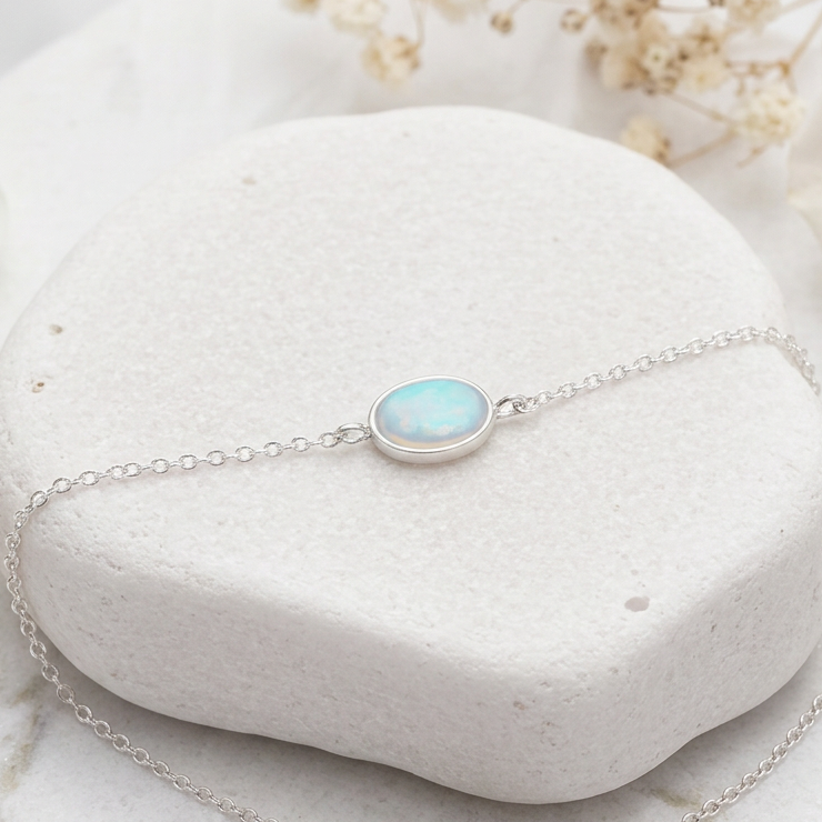 Sterling silver opal bracelet with a white opal on a white stone surface