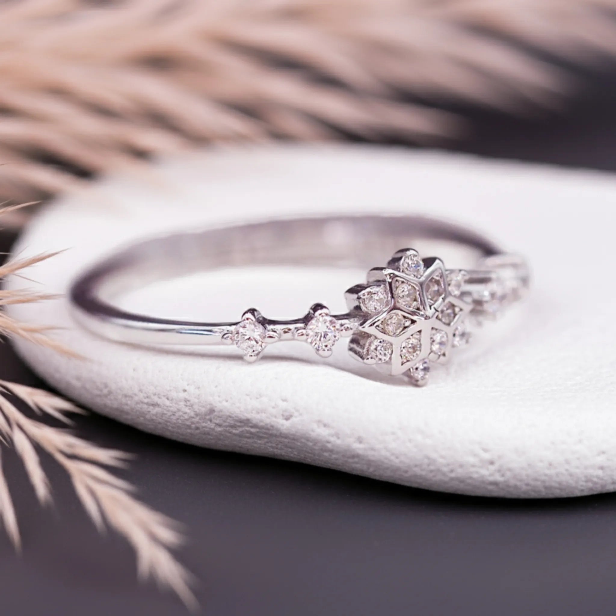 Silver ring with diamond accents on a white stone surface