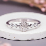 Silver ring with a snowflake design on a white stone surface