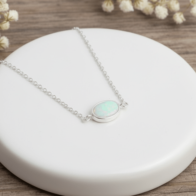 silver bracelet with a white opal pendant on a white stone surrounded by small white flowers